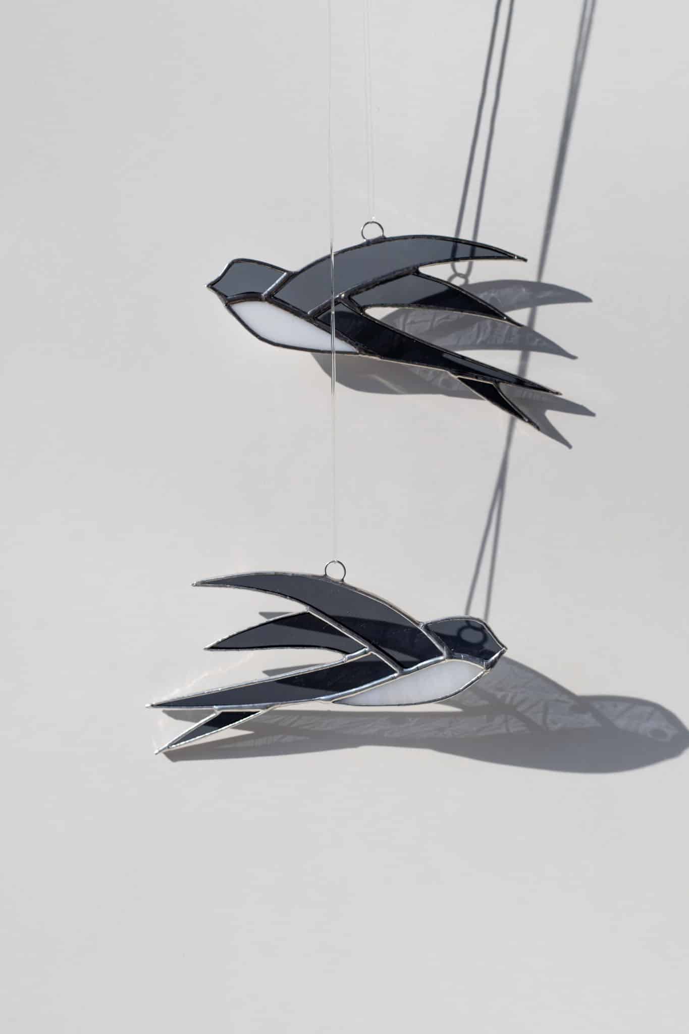 Ručne vyrobená vitrážová dekorácia v tvare letiacej lastovičky zavesená v okne